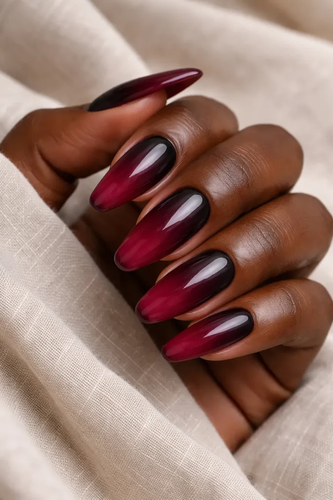 Subtle monochromatic ombre fading from deep burgundy to a lighter wine shade on dark skin.