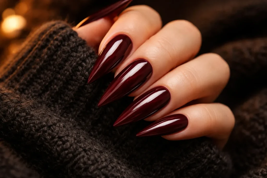 Deep burgundy wine-colored stiletto nails with a glossy finish
