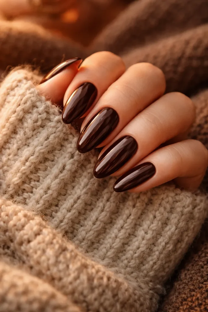 Rich chocolate brown nails for a cozy autumn look on a knit sweater