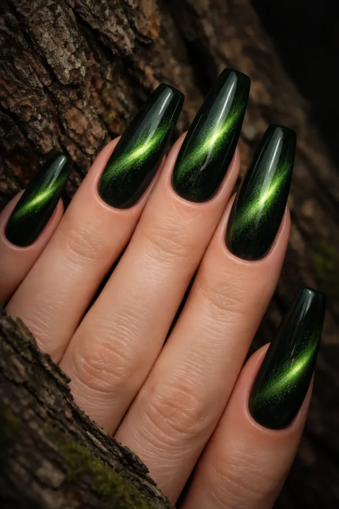 Dark forest green cat eye nails with a bright magnetic stripe against tree bark.