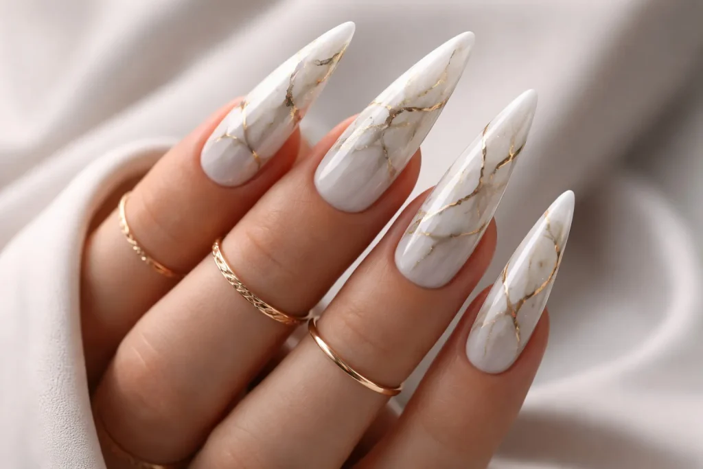 White marble stiletto nails with realistic grey and gold veining
