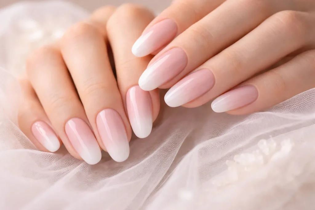 Soft ombre nude to white fade manicure on bridal hands