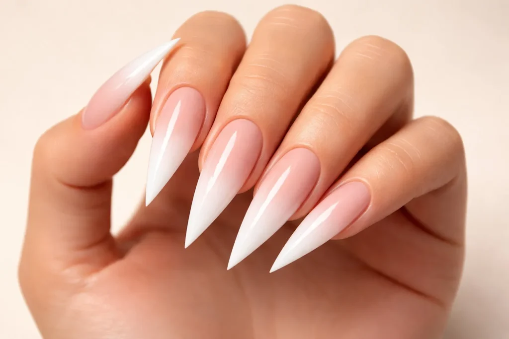 Nude to white ombre stiletto nails with a smooth gradient transition