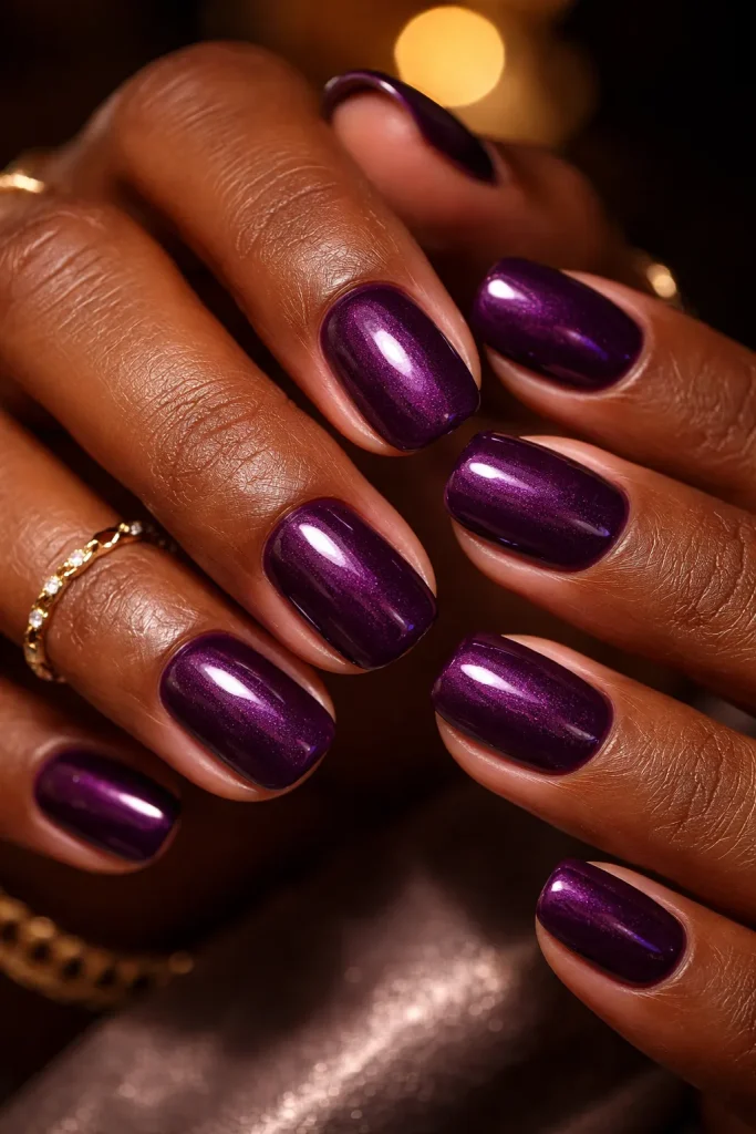 Short deep plum nails with subtle shimmer on dark skin