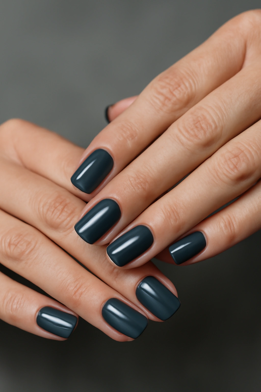 Close-up of hands with charcoal grey nails, modern chic