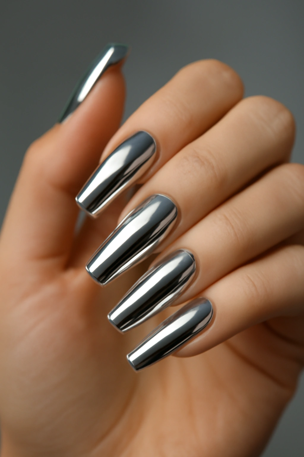 High-shine silver chrome nails with a reflective mirror finish on a professional manicure.