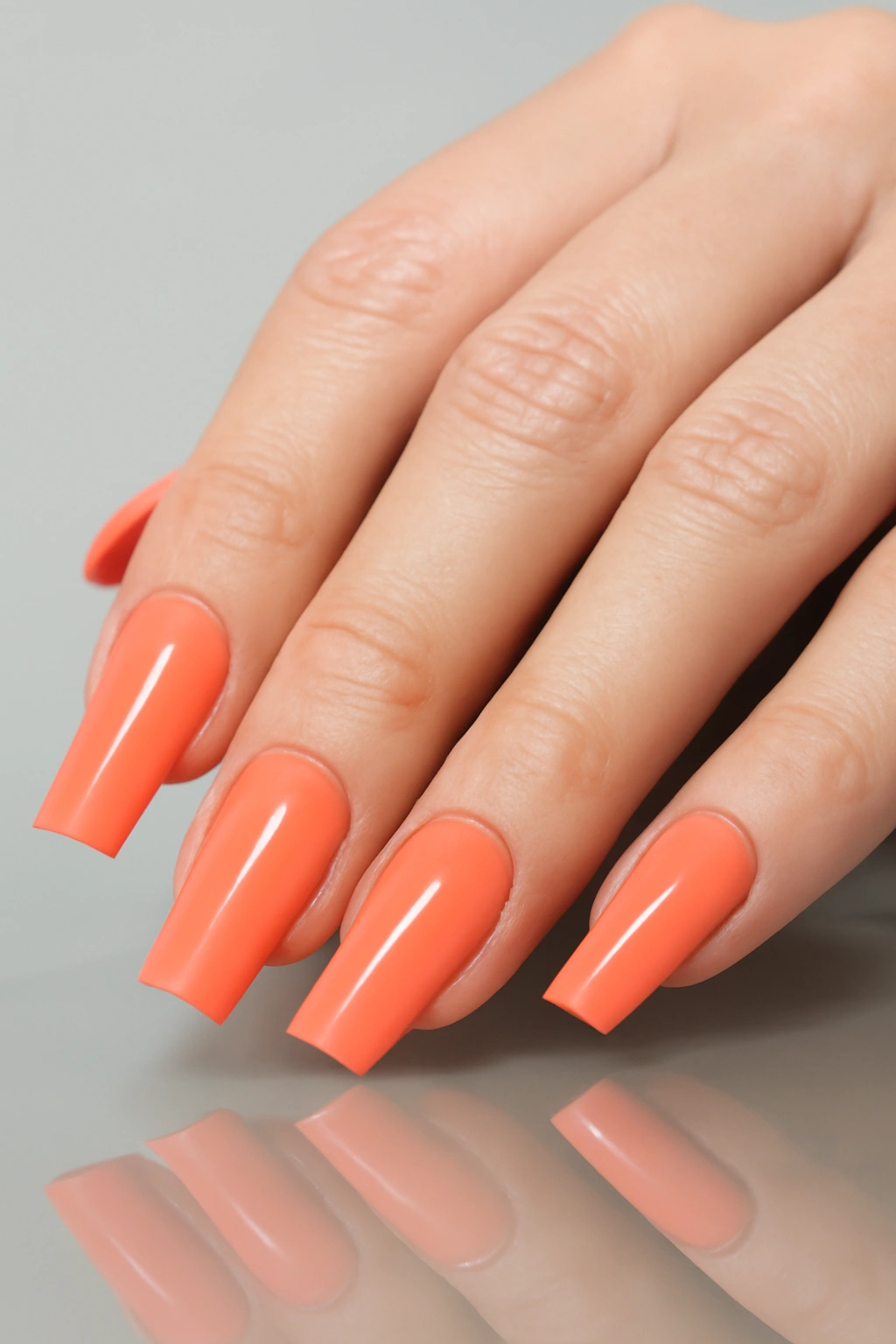 Duck feet nail shape with wide flared tips and coral polish