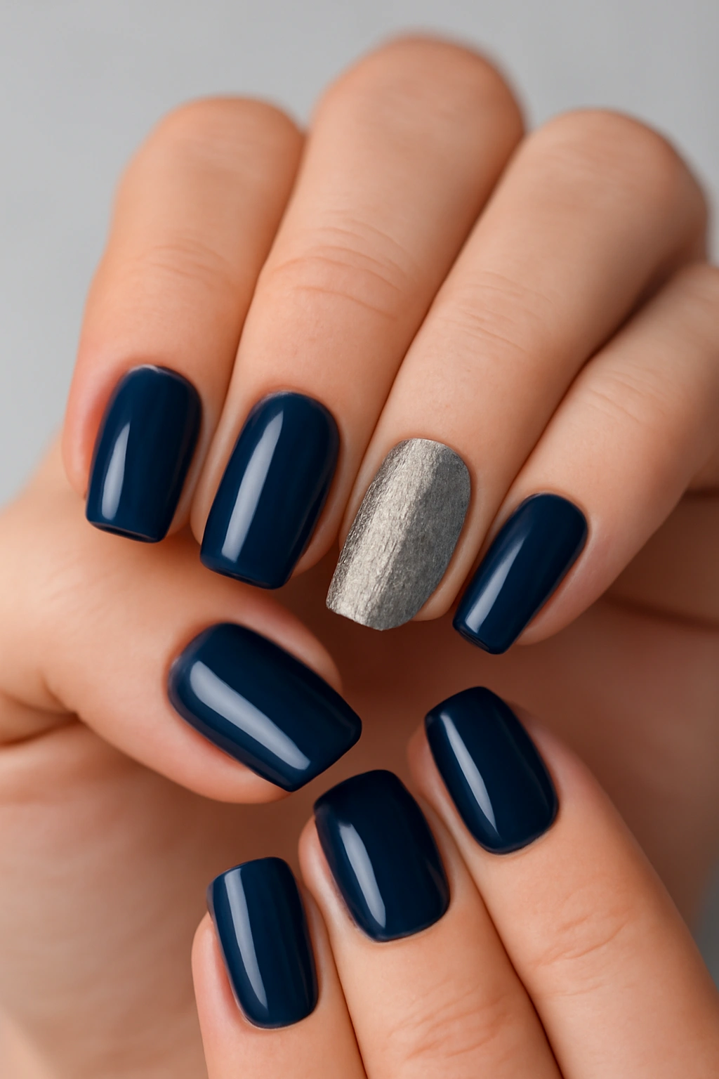 Navy blue manicure featuring a silver glitter accent nail.