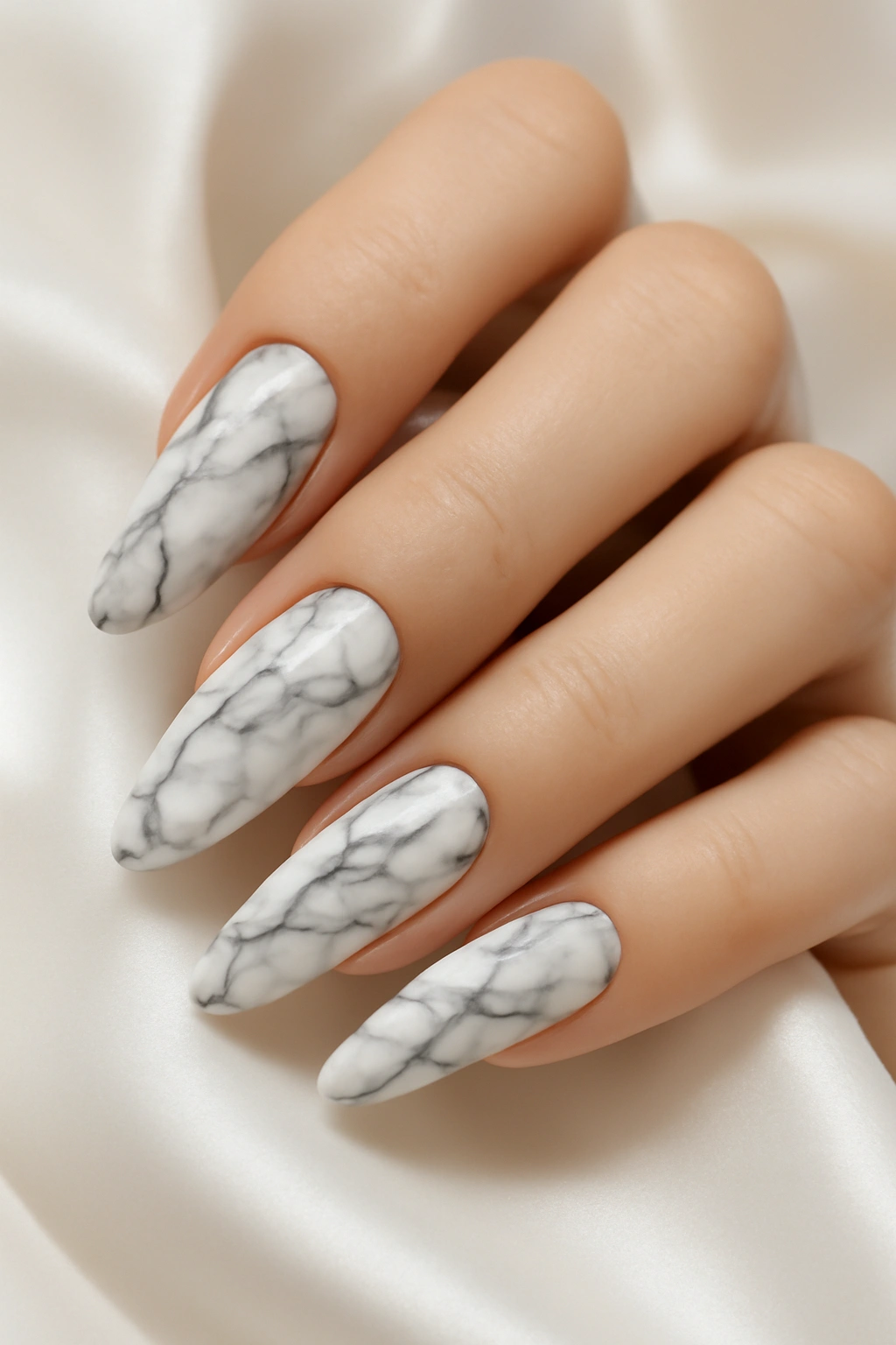 Luxury marble effect nail art with grey veining on a white background