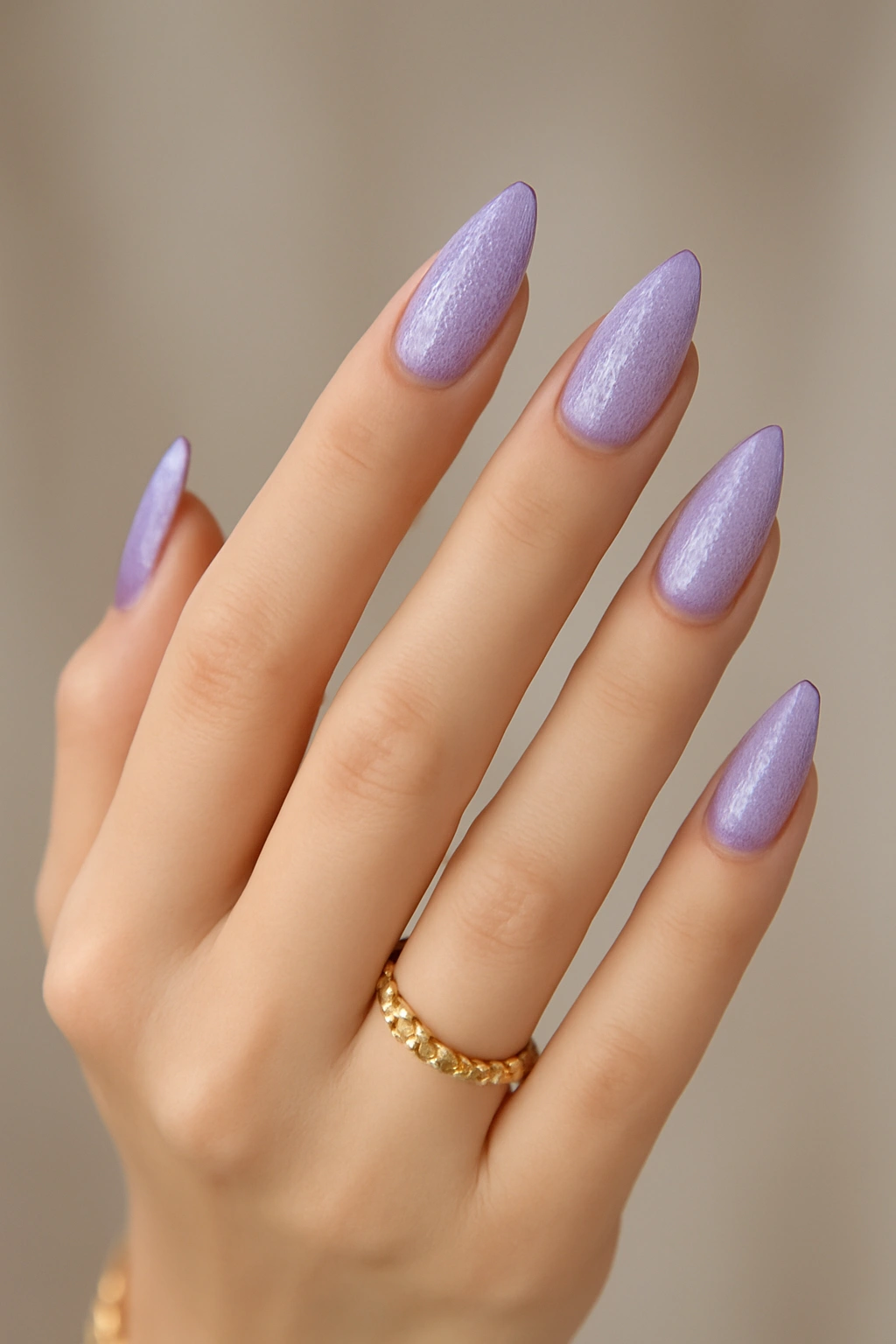 Lavender pointed oval nails on petite hands with a defined taper between oval and almond shapes.
