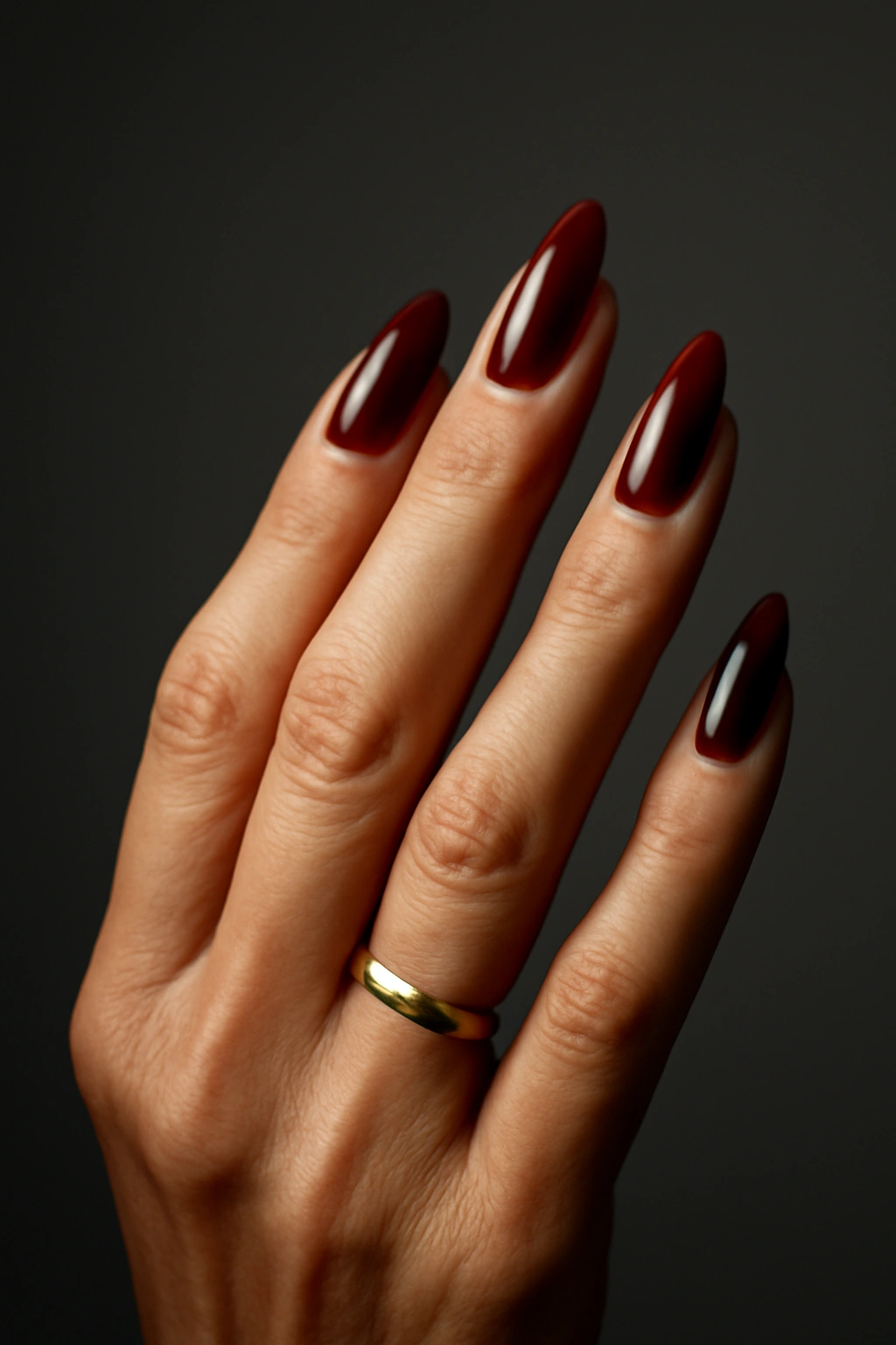 Subtle stiletto nails with burgundy polish on a woman over 50