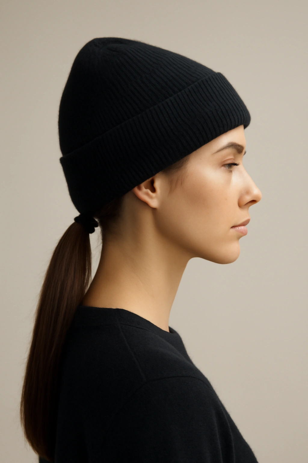 Sleek straight low ponytail under a flat beanie, minimalist studio